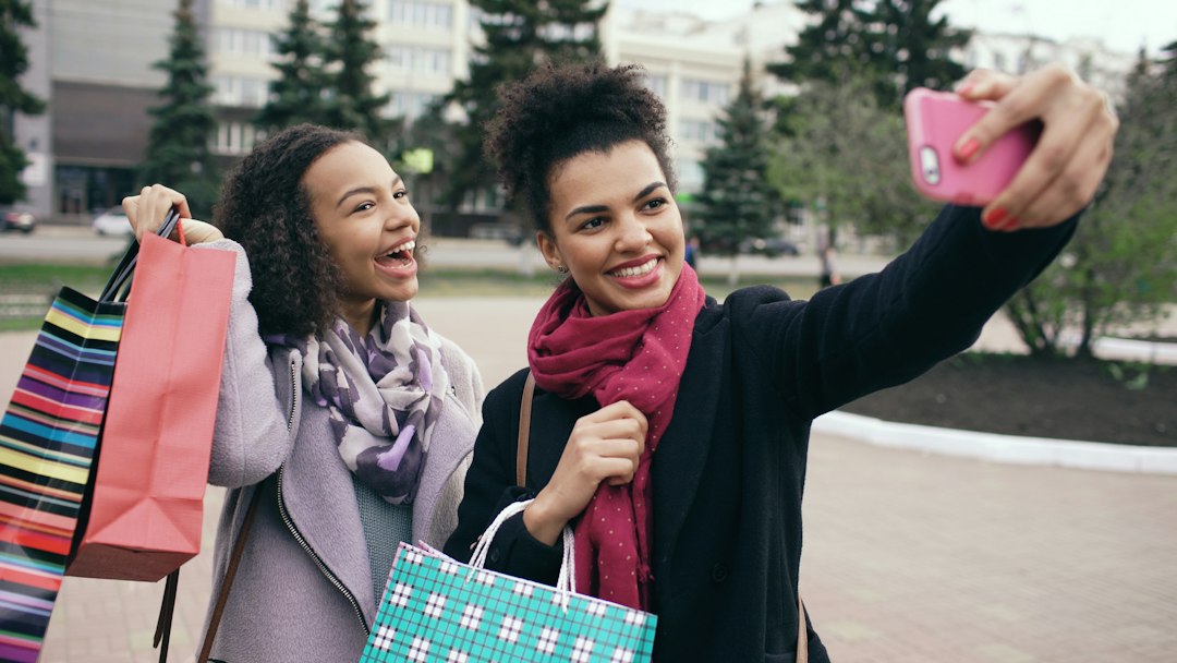 Two women taking a selfie with shopping bags