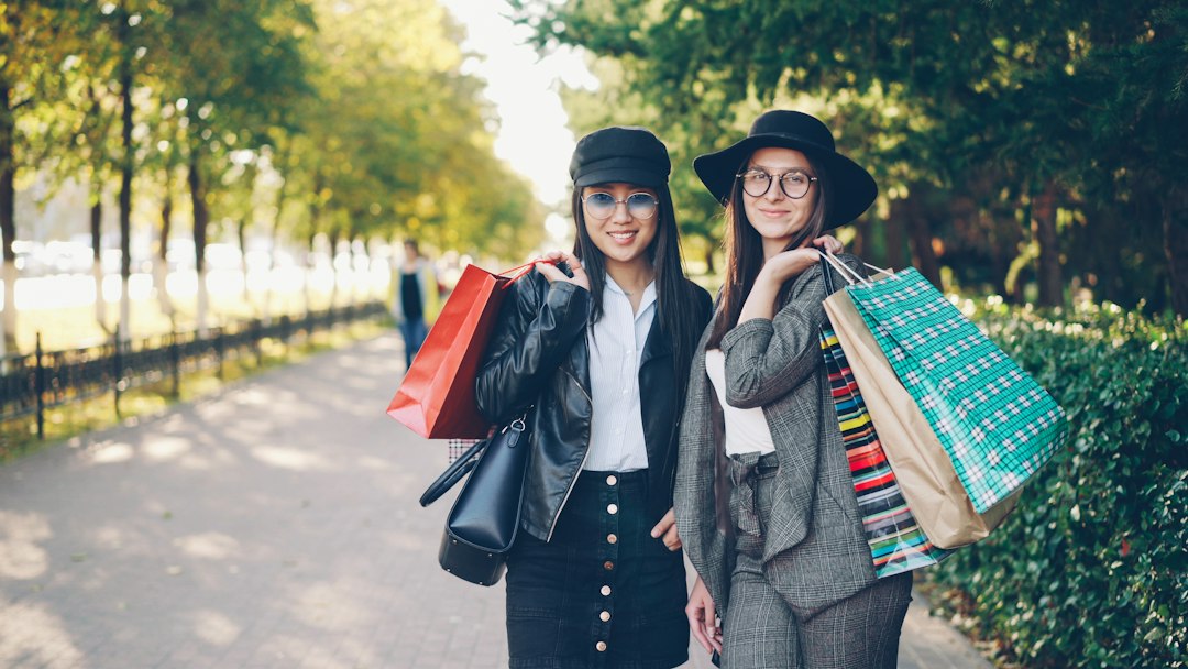 Two women with shopping bags in a park